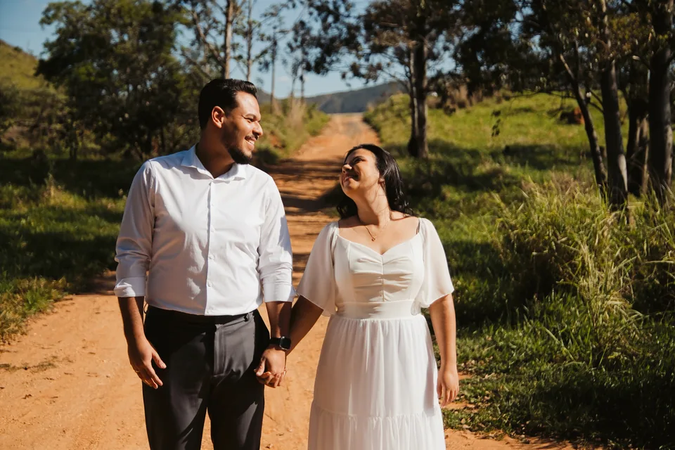 Bianca e Romeu caminhando de mãos dadas em uma estrada de terra