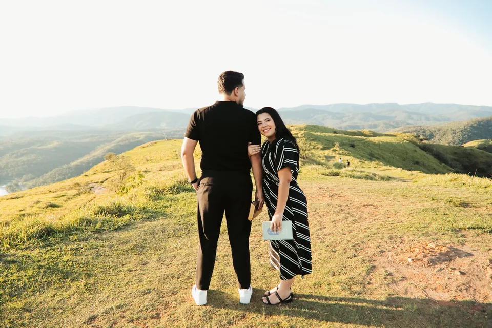 O casal caminhando junto no alto do campo